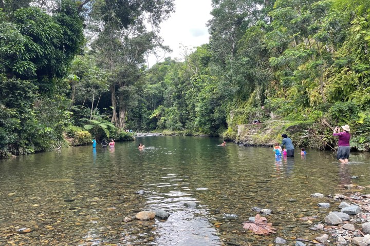 a group of people standing next to a lake